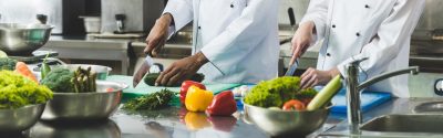 Two chefs cutting vegetables