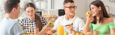 Teenagers eating a healthy meal together such as apples and orange juice