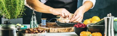 The hands of a person preparing a chicken to be cooked